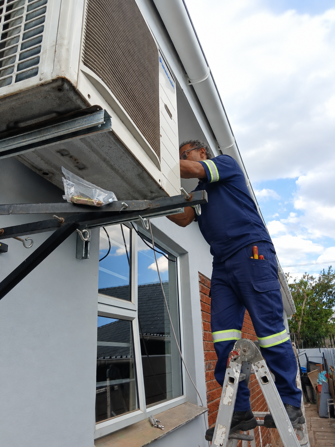 Swiftech technician servicing an outdoor air conditioning condenser unit